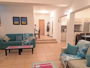 Ein Wohnzimmer mit Sofa, Couchtisch und einem Essbereich mit Stühlen und Tisch.