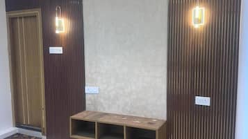 Un interior moderno con puerta de madera, iluminación empotrada y un banco integrado.