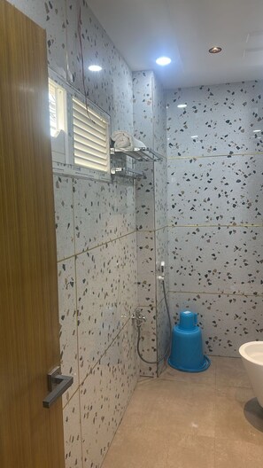 A bathroom with a shower, a toilet, and a sink. - Hotel Krishna & Restaurant (Barharwa)