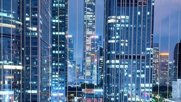Un edificio alto con vista a un paisaje urbano al anochecer.