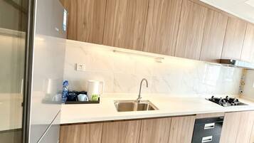 Una cocina moderna con armarios de madera, un lavamanos de acero inoxidable y un lavavajillas.