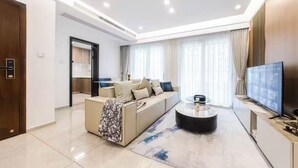 Una sala de estar moderna con sofá, mesa de centro y televisor.