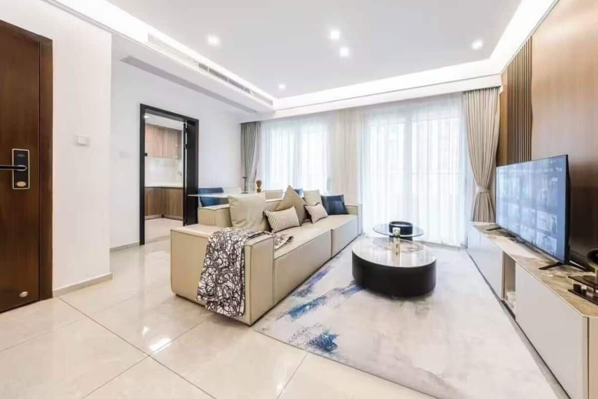 Una sala de estar moderna con sofá, mesa de centro y televisor.