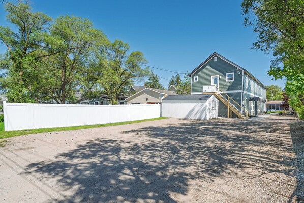 Et toetagers hus med en veranda, en overdækket indkørsel og en hegnet have.