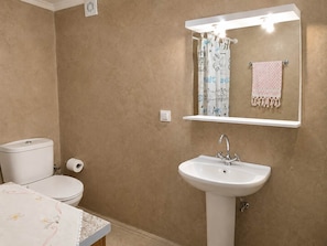 Ein Badezimmer mit Toilette, Waschbecken und Spiegel.