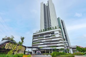 Un edificio moderno de varios pisos con una entrada destacada y un letrero que dice 'GREENFIELD'.