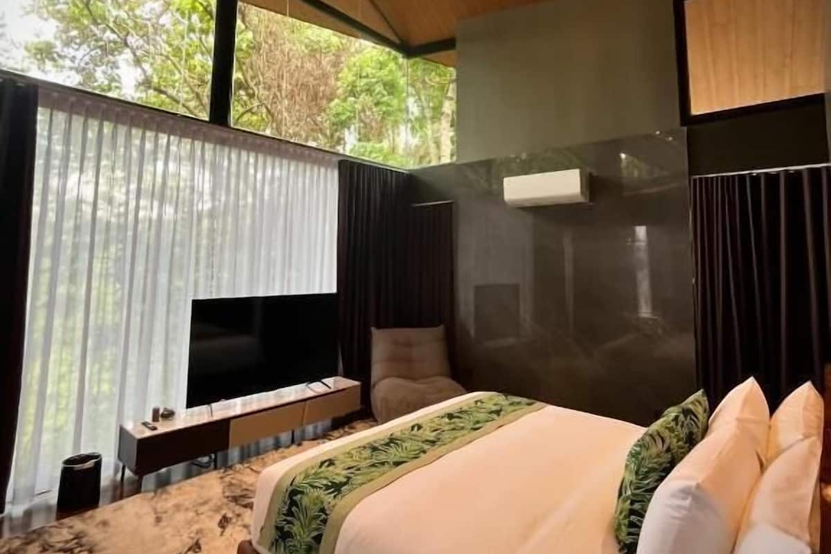Un dormitorio moderno con una cama grande, un televisor y techo de madera.