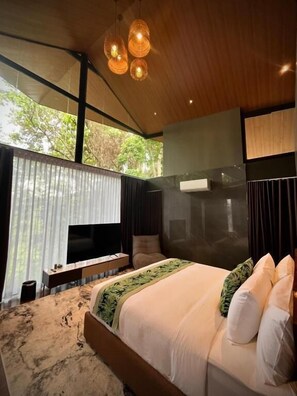 A modern bedroom with a large bed, a TV, and a wooden ceiling. - House of Gaia (Lipa City)