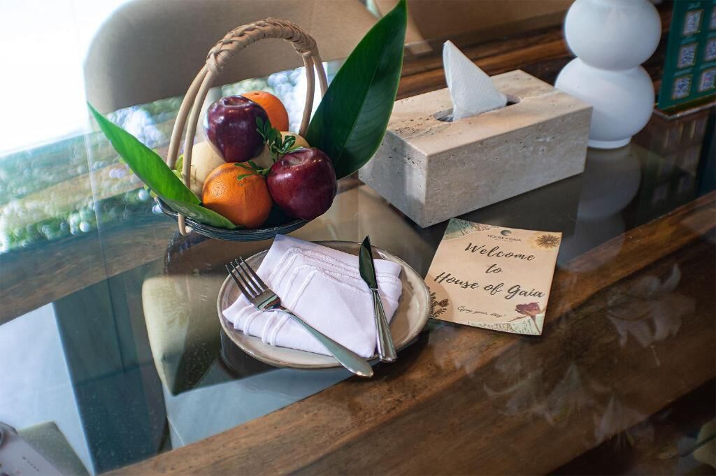 A reception area with a wicker basket of fruit, a tissue box, a folded napkin, and a welcome sign.