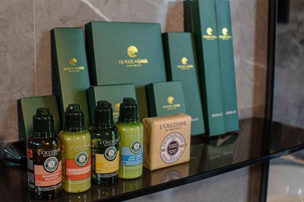 A display of L'OCCITANE products including shampoo, conditioner, and body lotion.
