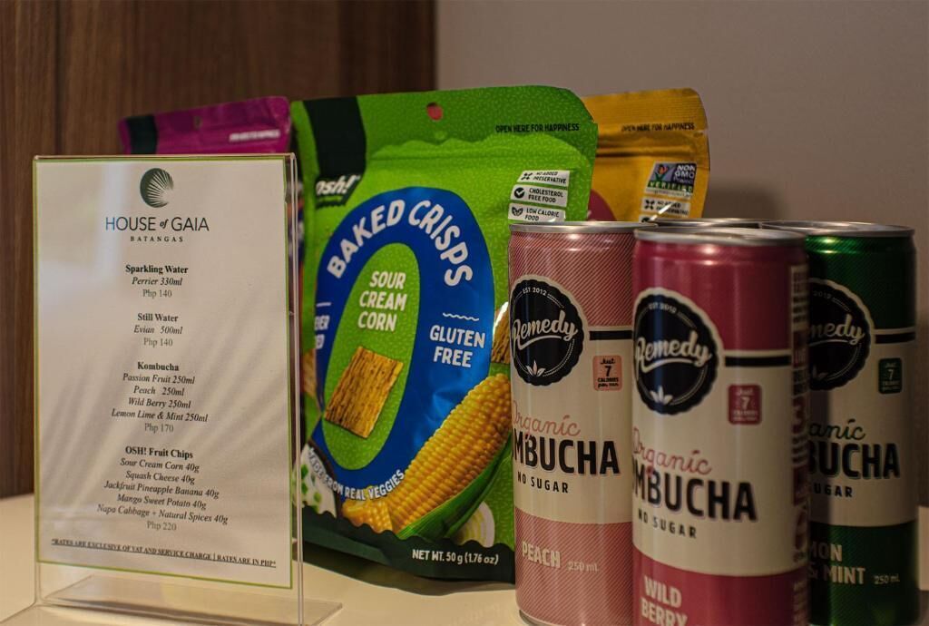 Diversos alimentos embalados, incluindo água com gás, batatas fritas assadas, kombucha e bebidas enlatadas.