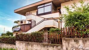 Un bâtiment à deux étages doté d’un balcon, d’un escalier et d’un mur en béton.