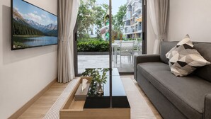 Ein modernes Wohnzimmer mit einer Couch, einem Couchtisch und einem an der Wand befestigten Fernseher.