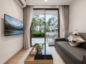 Ein modernes Wohnzimmer mit einer Couch, einem Couchtisch und einem an der Wand befestigten Fernseher.