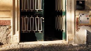 Un ingresso di un edificio con un'ampia porta ad arco, il numero civico '46' e un pavimento in pietra.