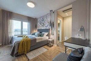 A modern bedroom with a bed, bedside table, and a view of the outdoors.