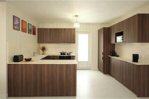Eine moderne Küche mit Holzausstattung, einer zentralen Kochinsel, einer Mikrowelle und einem Spülbecken.