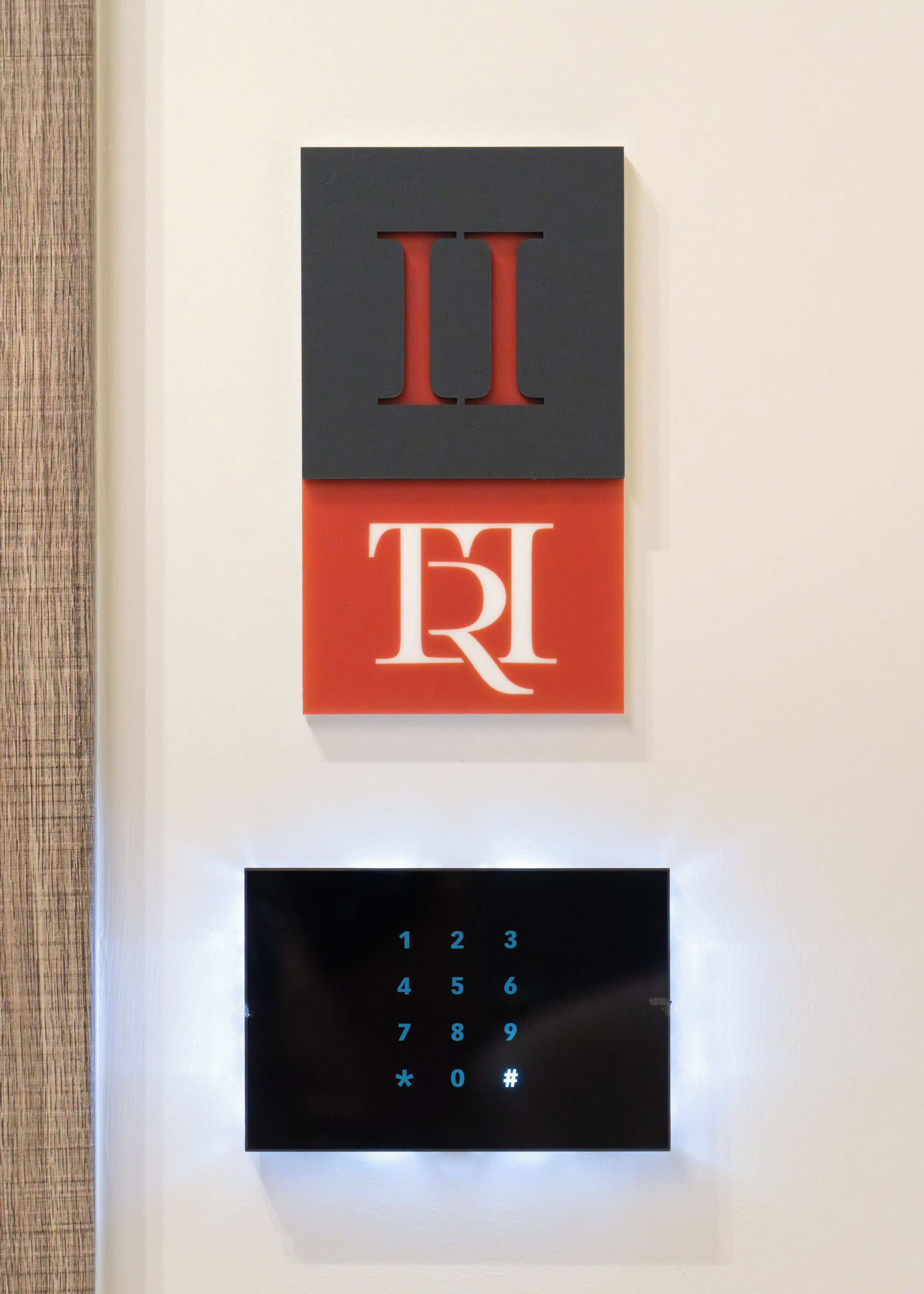 A wall-mounted numeric keypad with numbers 1-9, *, 0, and #.
