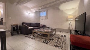 Een woonkamer met een bank, salontafel en televisie.