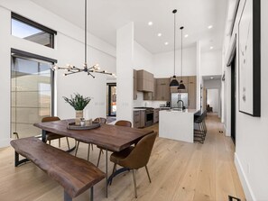A modern kitchen with wooden cabinets, a central island, and pendant lighting. - Modern Mountain Villa Near Deer Valley, Sleeps 14 (Heber City)