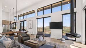 Un amplio salón con un sofá grande, una mesa de comedor y una chimenea.