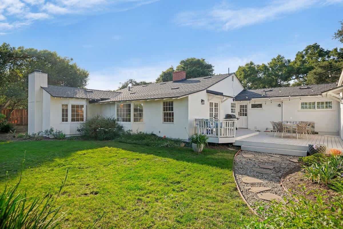 A two-story house with a covered patio and a well-maintained lawn.