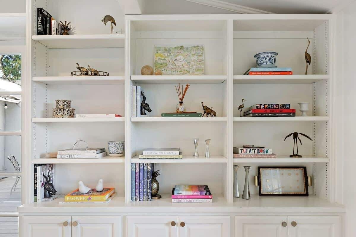 A white shelving unit with various decorative items and books.