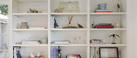 Un estante blanco con varios objetos decorativos y libros.