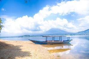 A boat on a calm lake with a mountain in the background.