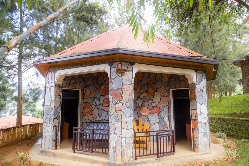 Uma construção de pedra com telhado em cerâmica, duas portas e uma pequena varanda com guarda-corpo.