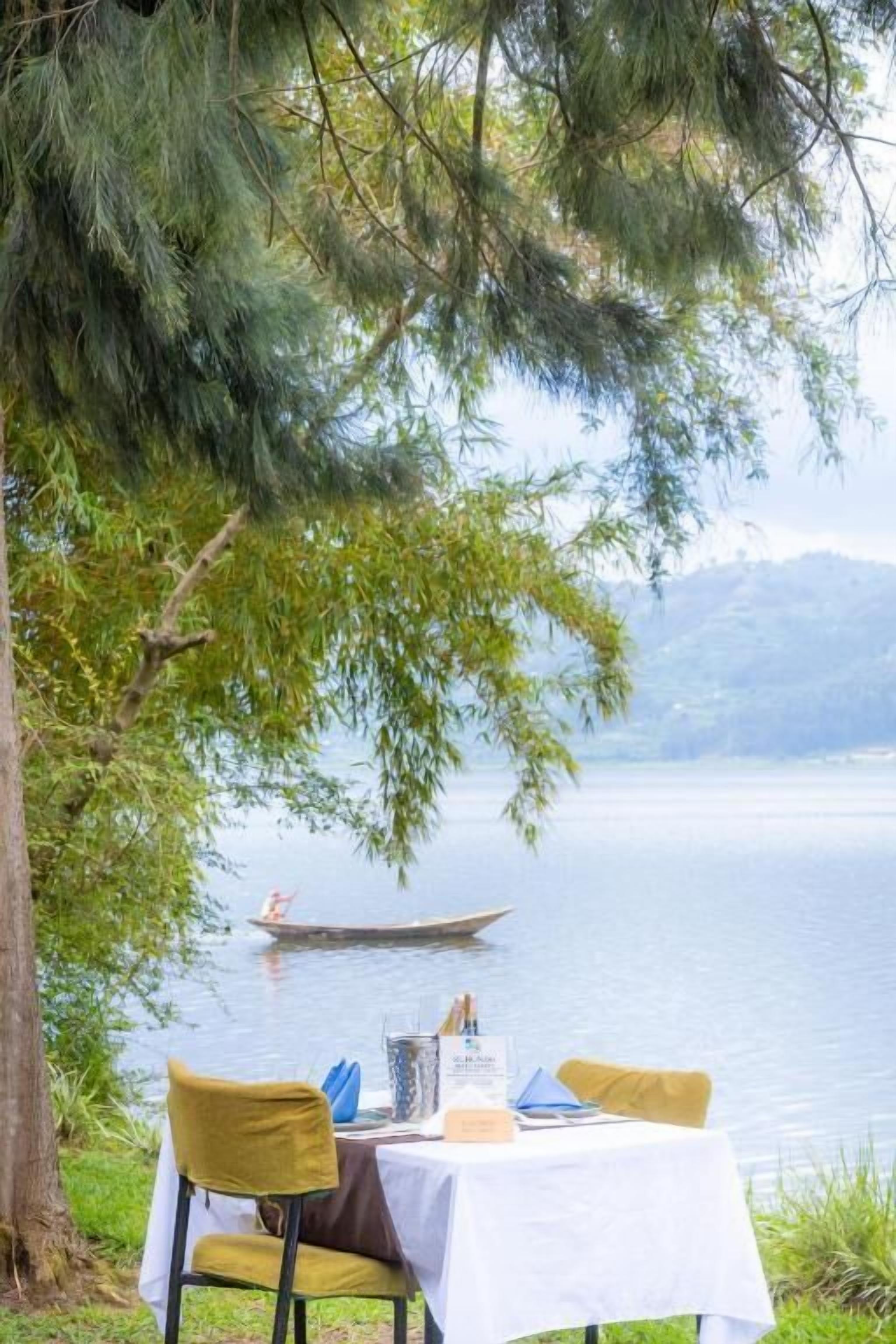 Mesa al aire libre con vista a un lago y un barco a lo lejos.