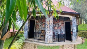 A stone building with a red roof, two doors, and a small porch with railings. - Ruhondo Beach Resort (Gashaki)