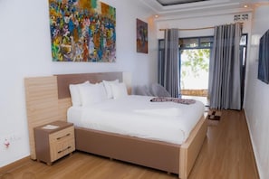 Un dormitorio moderno con una cama grande, una mesita de noche, un cabecero de madera y un cuadro abstracto y colorido en la pared.