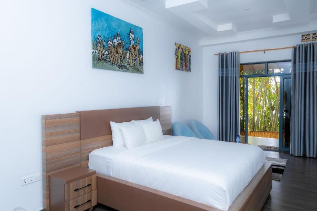 Une chambre à coucher avec un lit, une table de chevet, un tableau et une vue par la fenêtre.