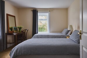 A bedroom with two beds, a desk with a chair, a mirror, and a window with curtains. - Beautiful 4 bdrm Farmhouse with ocean views, Fife. (Kirkcaldy)