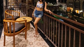 A balcony with a pool, wooden chairs, and a railing. - Tiger Aura resort (Ramnagar)
