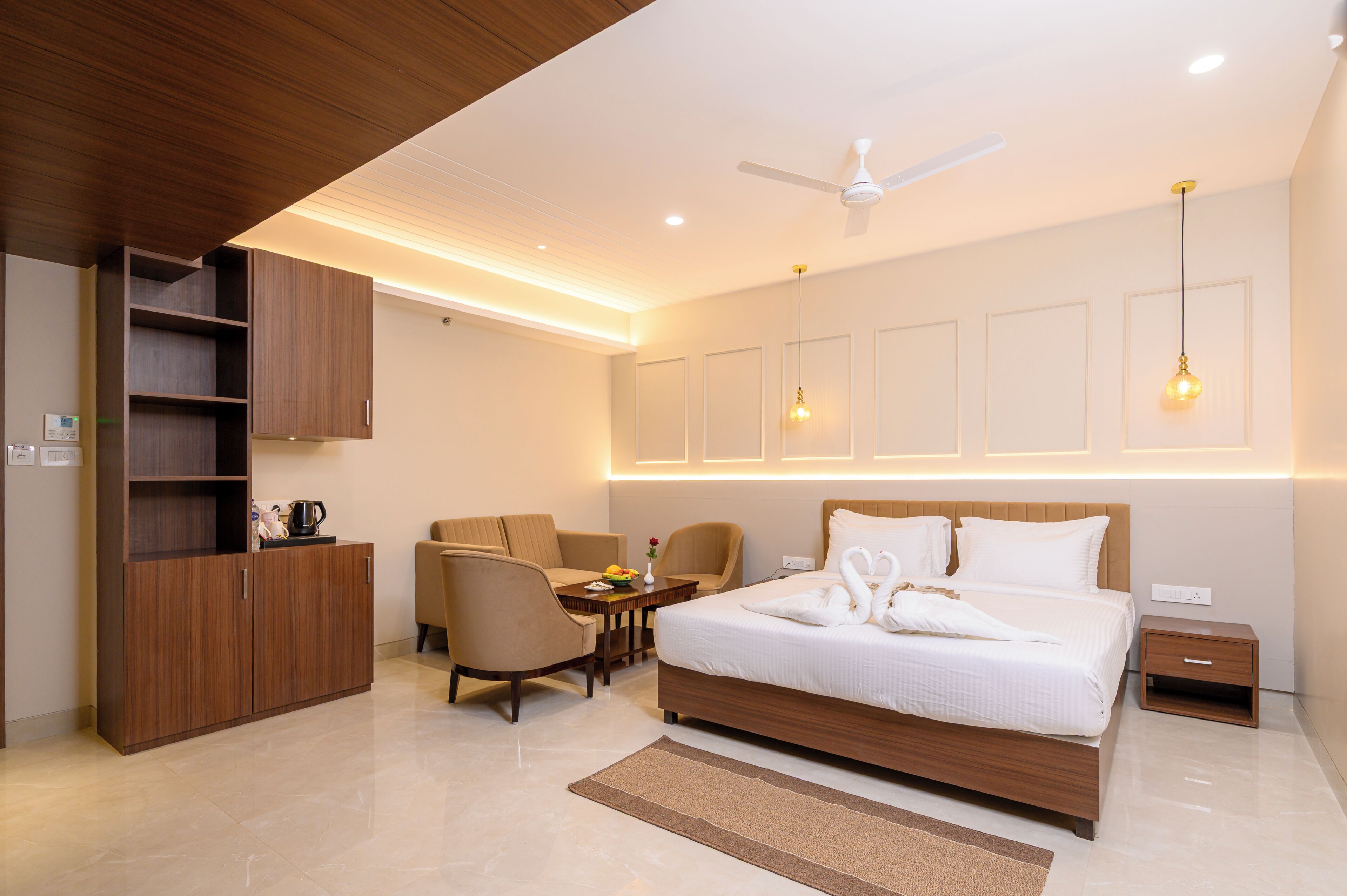 A modern hotel room with a bed, a desk, a chair, a wardrobe, and a ceiling fan.