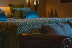 Een bed met een geribbelde deken, een houten hoofdbord en meerdere kussens.