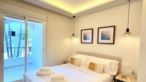 Quarto de hotel com cama, mesa de cabeceira, moldura de quadro, luz no teto e vista para o exterior.
