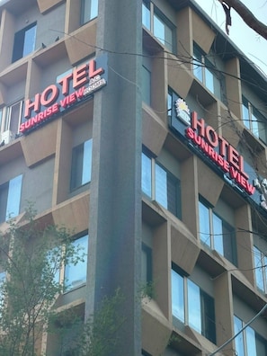 A multi-story building with signs for 'HOTEL SUNRISE VIEW' and 'HOTEL SUNRISE VIEWS.' - Hotel Sunrise View (Ahmedabad)
