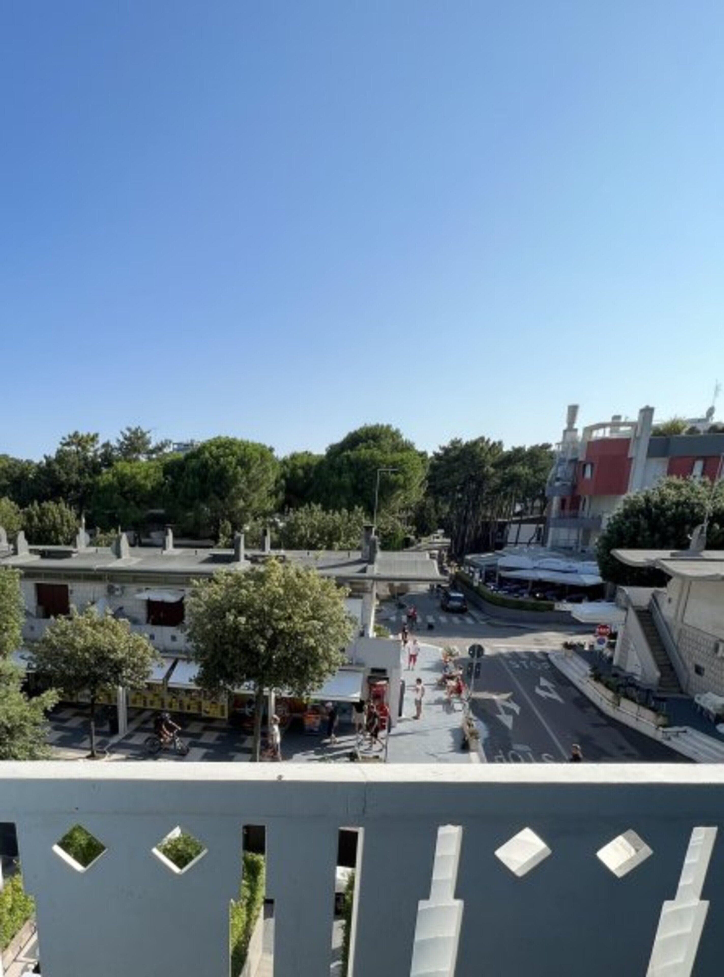 Une vue de rue avec des bâtiments, des arbres et un ciel dégagé.