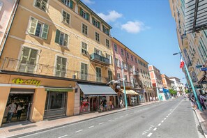 Eine Straße mit Gebäuden, ein Geschäft mit der Aufschrift 'city' und einem klaren Himmel.