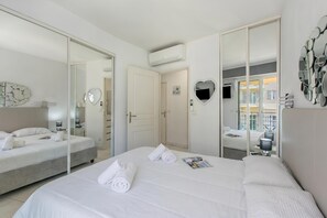 Ein Hotelzimmer mit einem großen Bett, einem Nachttisch, einem Spiegel und einem Kleiderschrank.
