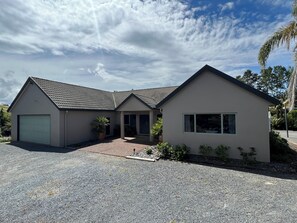 Een twee verdiepingen tellend huis met garage, overdekte veranda en oprit.