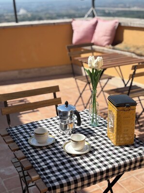 A checkered table with a coffee pot, cups, and a container on a terrace with a view. - Vrbo Property (Frascati)
