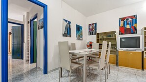 Ein moderner Essbereich mit Tisch, Stühlen und einem Fernseher.