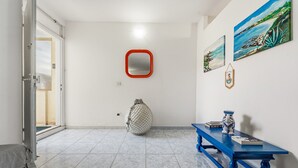 Ein Flur mit einem blauen Tisch, einem Spiegel und Kunstwerken an der Wand.