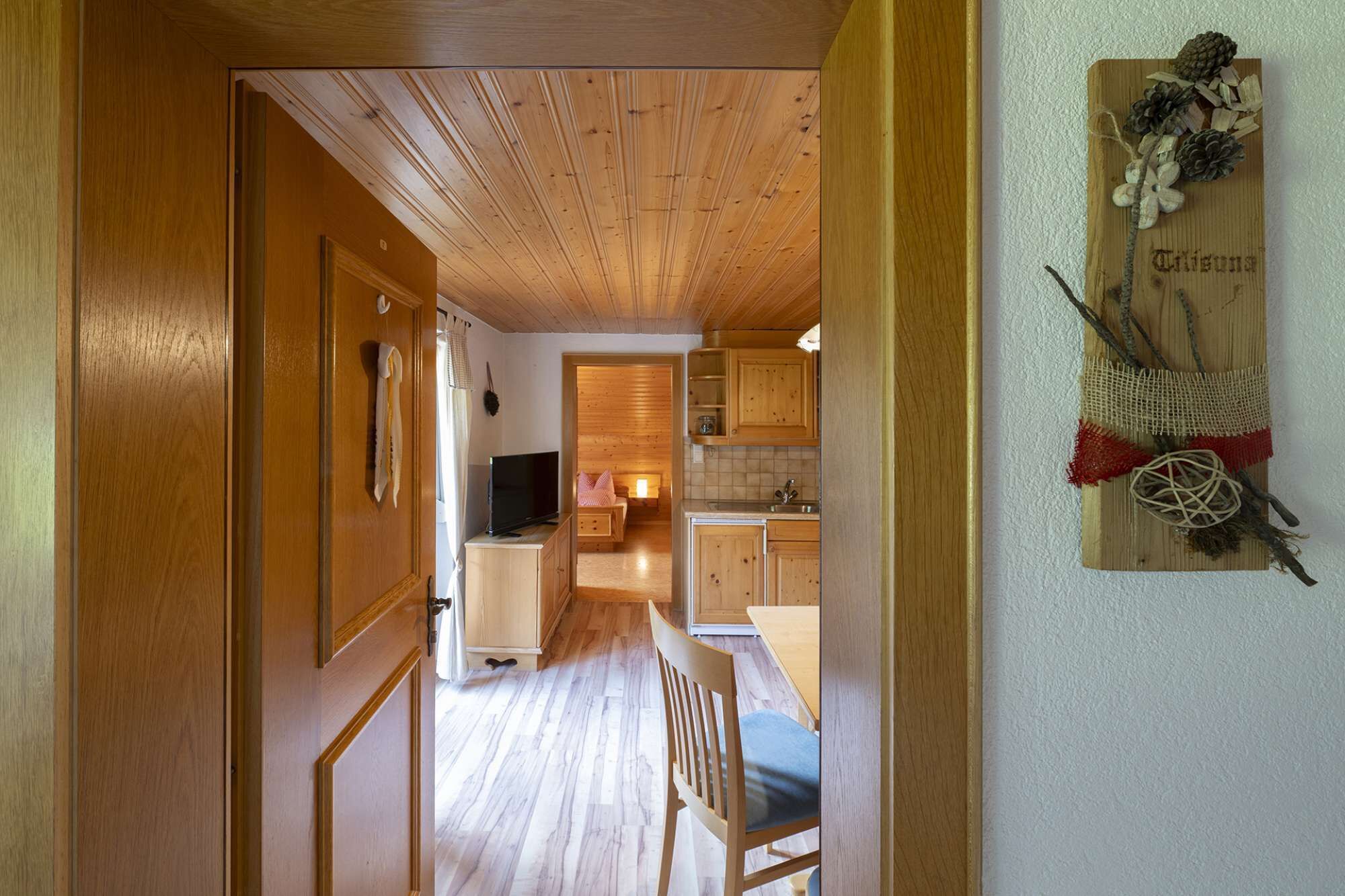 Un interno in legno con cucina, zona pranzo e soggiorno.