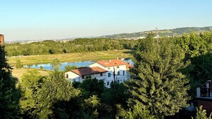 A view of a lake, trees, and buildings in a rural setting. - HOTEL IL MULINO (Casalgrande)