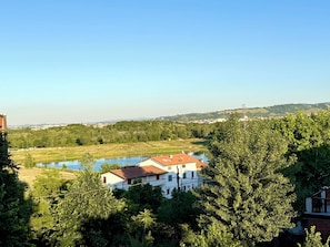 A view of a lake, trees, and buildings in a rural setting. - HOTEL IL MULINO (Casalgrande)